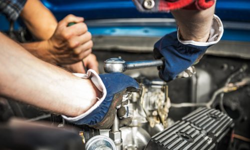 Two Caucasian Professional Car Mechanics Performing Gasoline Engine Repair
