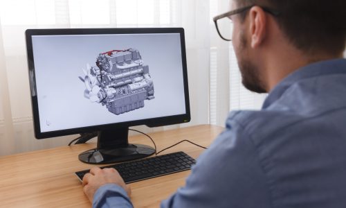 Engineer, Constructor, Designer in Glasses Working on a Personal Computer. He is Creating, Designinga New 3D Model of Car Engine, Motor in CAD Program. Freelance Work, LOS ANGELES, CALIFORNIA - 25.10.2019.