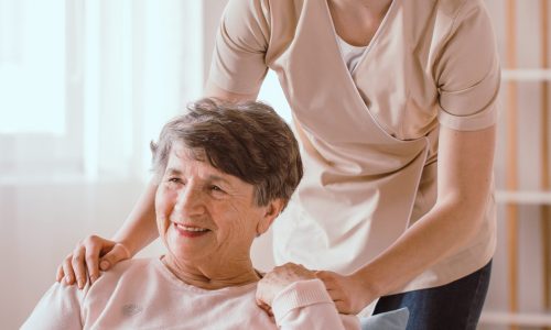 Young caregiver helping an older woman in the nursing house