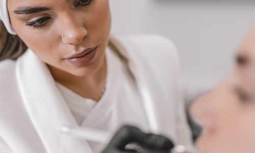 Vertical portrait with focus on a concentrated beauty doctor working in a beauty treatment clinic