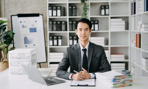 Young business man executive manager looking at laptop watching online webinar training or having virtual meeting video conference doing market research working in modern office.