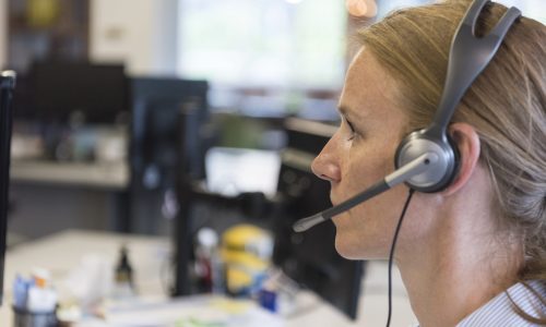 female customer support phone operator with headset  at workplace